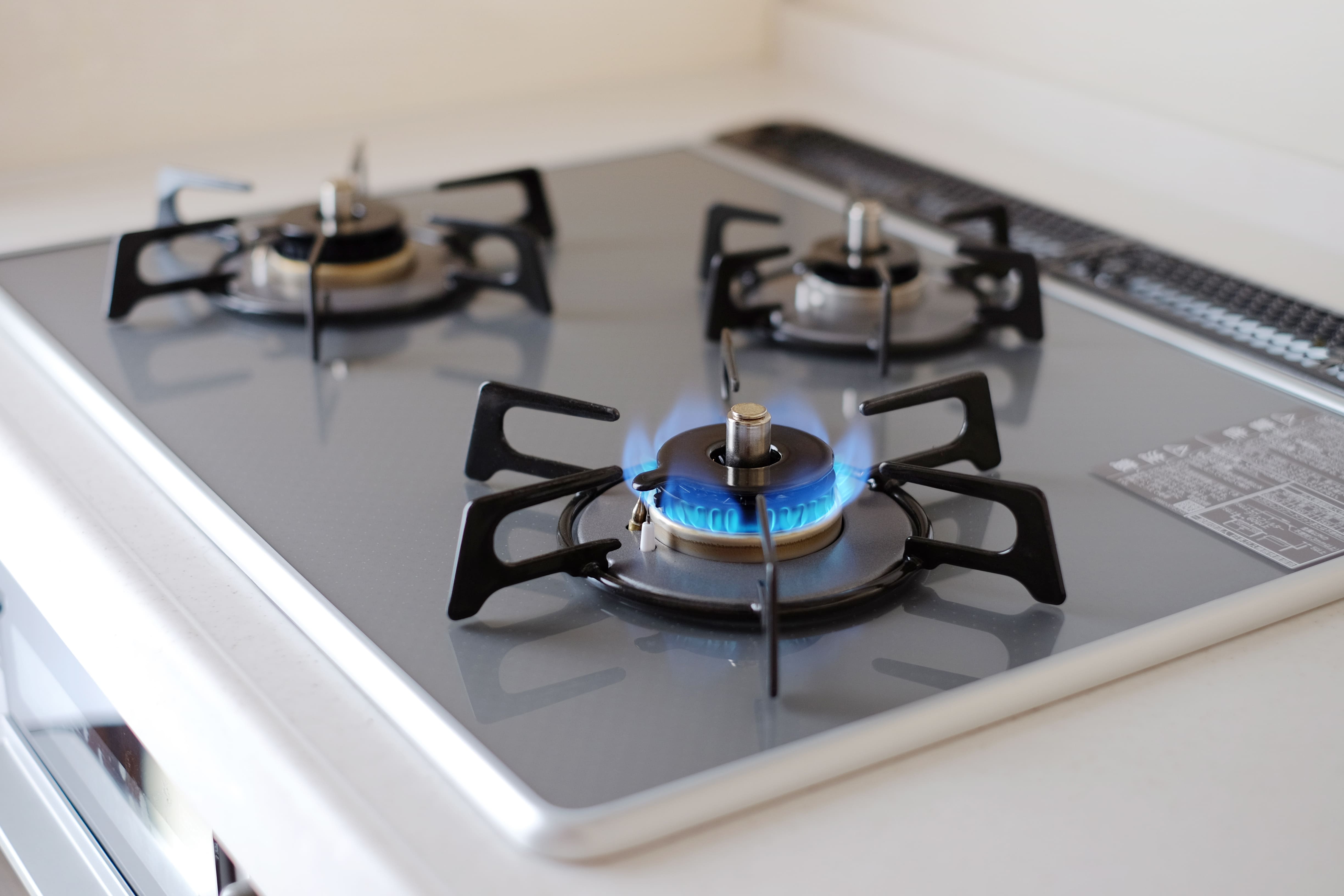 青い炎が燃えるグレーの天板の3口ガスコンロ